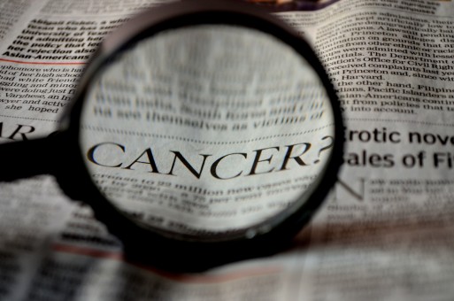 Magnifying glass looking at the word cancer