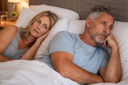 Couple in bed looking stressed
