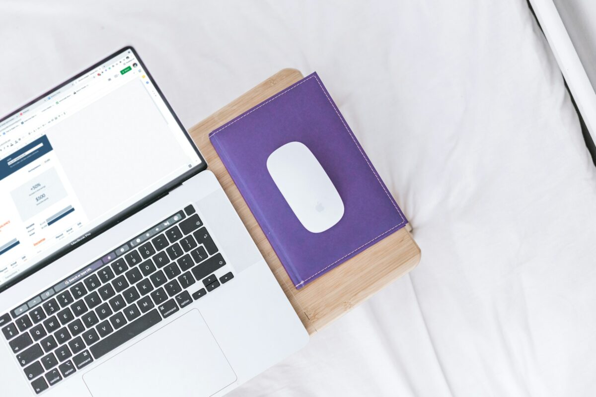 open laptop with purple notebook
