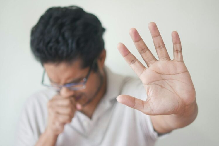 Man telling people to stay away while coughing.