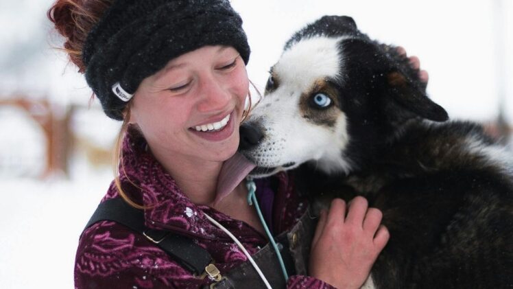 Dog licking a woman's face.