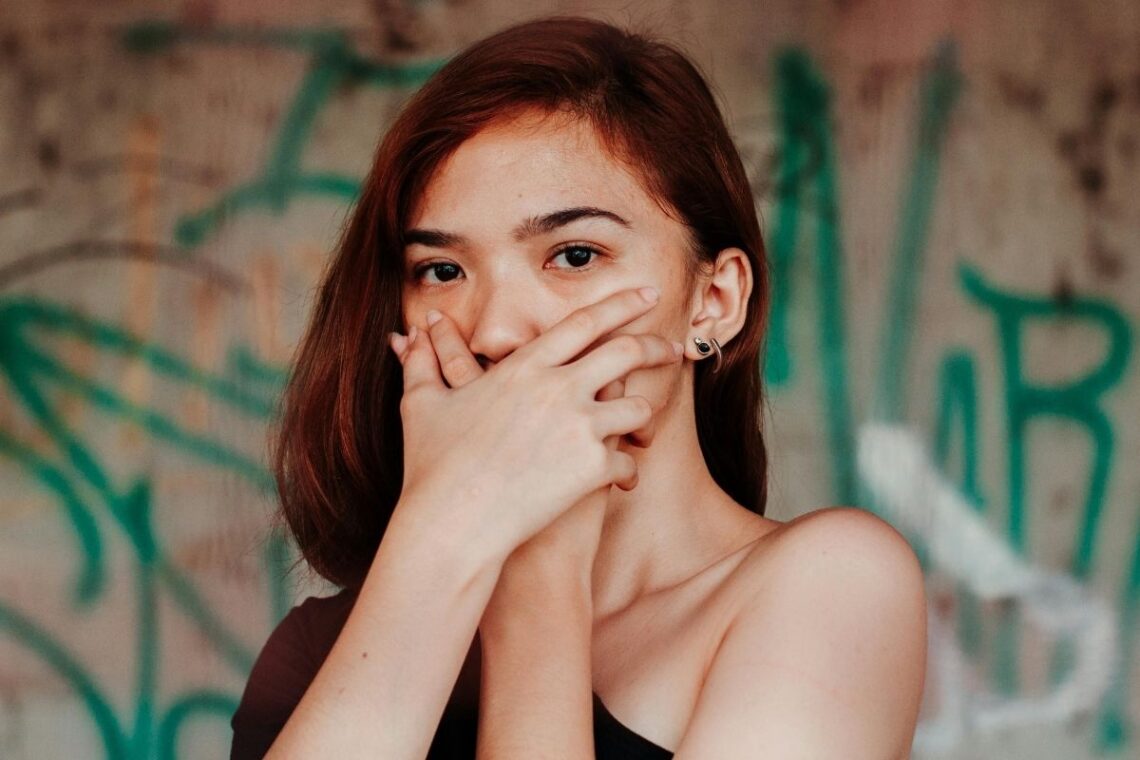 Woman with hands over her mouth.