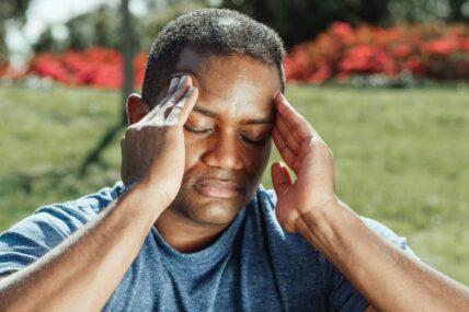 Man rubbing temples on head.