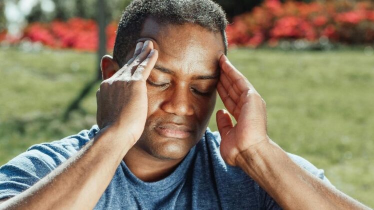 Man rubbing temples on head.