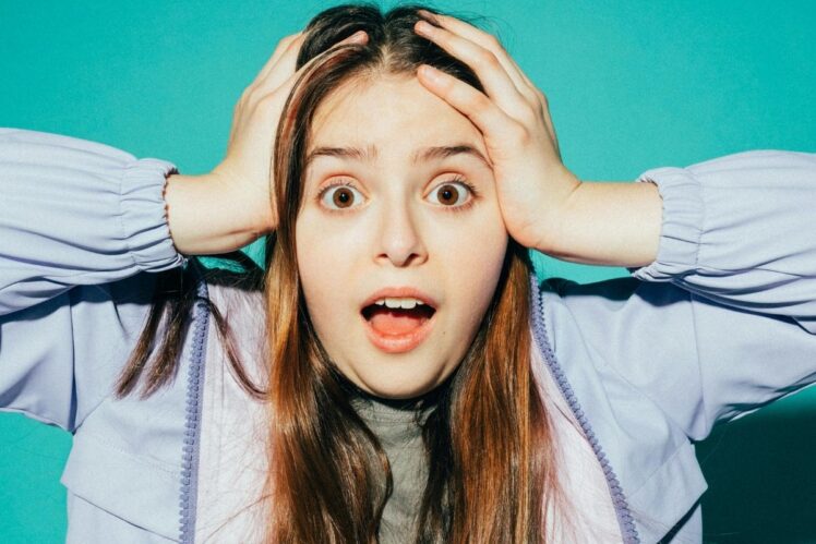 Stressed person holding their head.