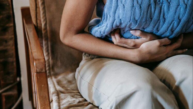 Woman holding stomach in pain.