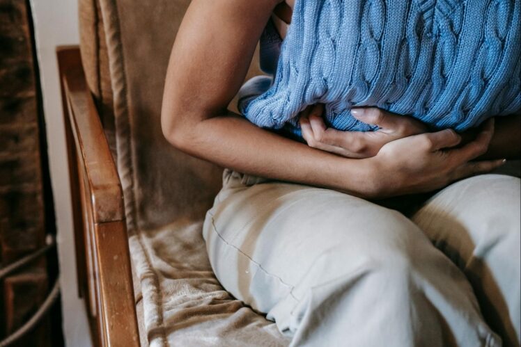 Woman holding stomach in pain.