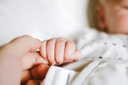 Baby grabbing a parents finger.