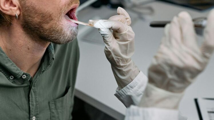Doctor examining patient with mouth open.