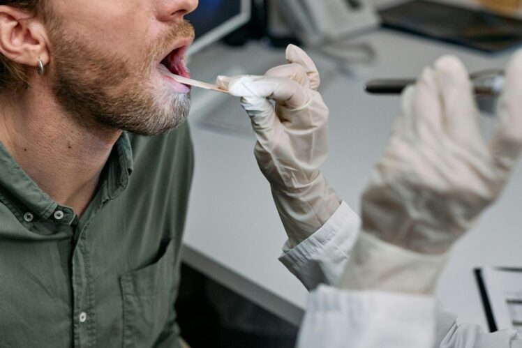 Doctor examining patient with mouth open.