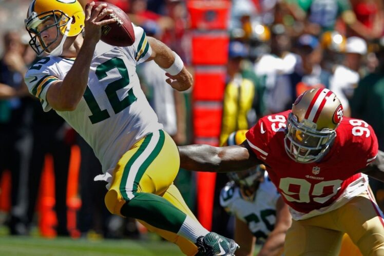 Aaron Rodgers slips while trying to scramble out of the pocket away from San Francisco 49ers linebacker Aldon Smith.