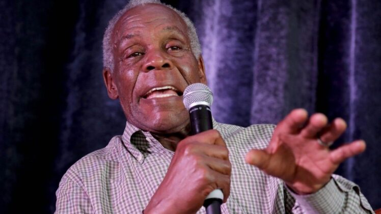Actor Danny Glover speaking into a microphone.